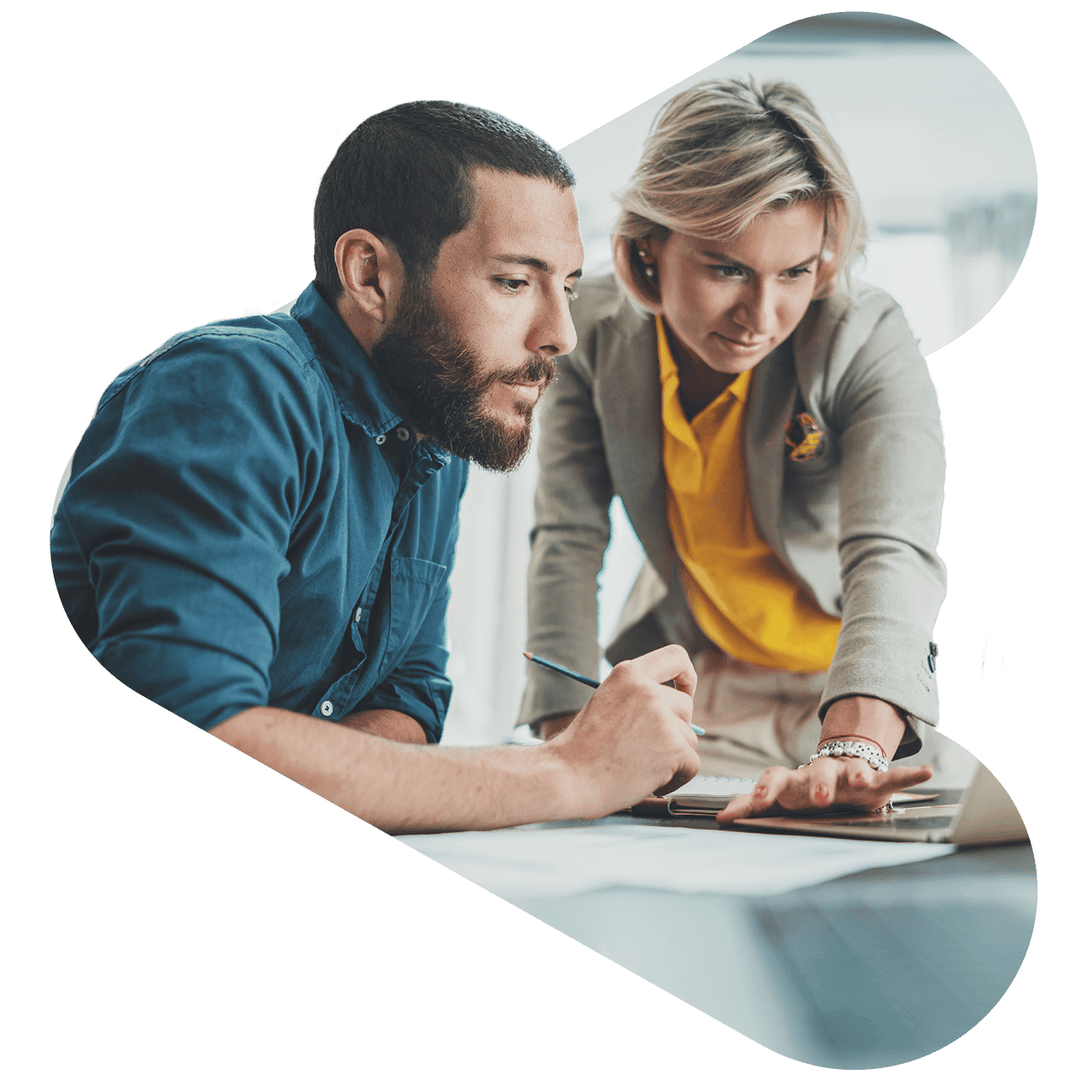 Two financial advisors focusing on a report on a laptop, collaborating with each other