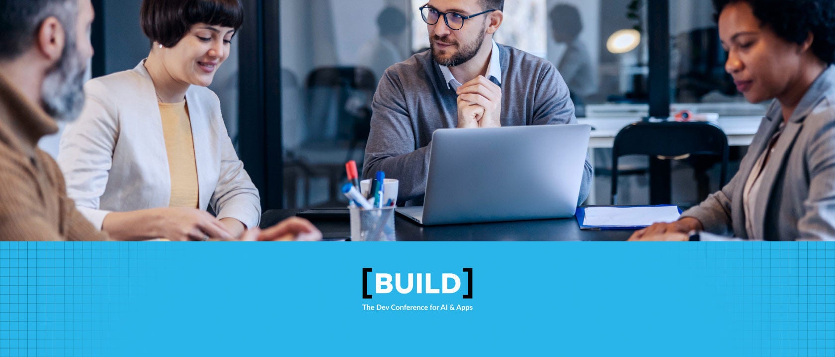 Photo of people sitting at an office table having a conversation, with the BUILD 2024 logo below the photo.