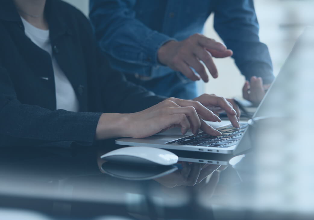 Two people working at a laptop