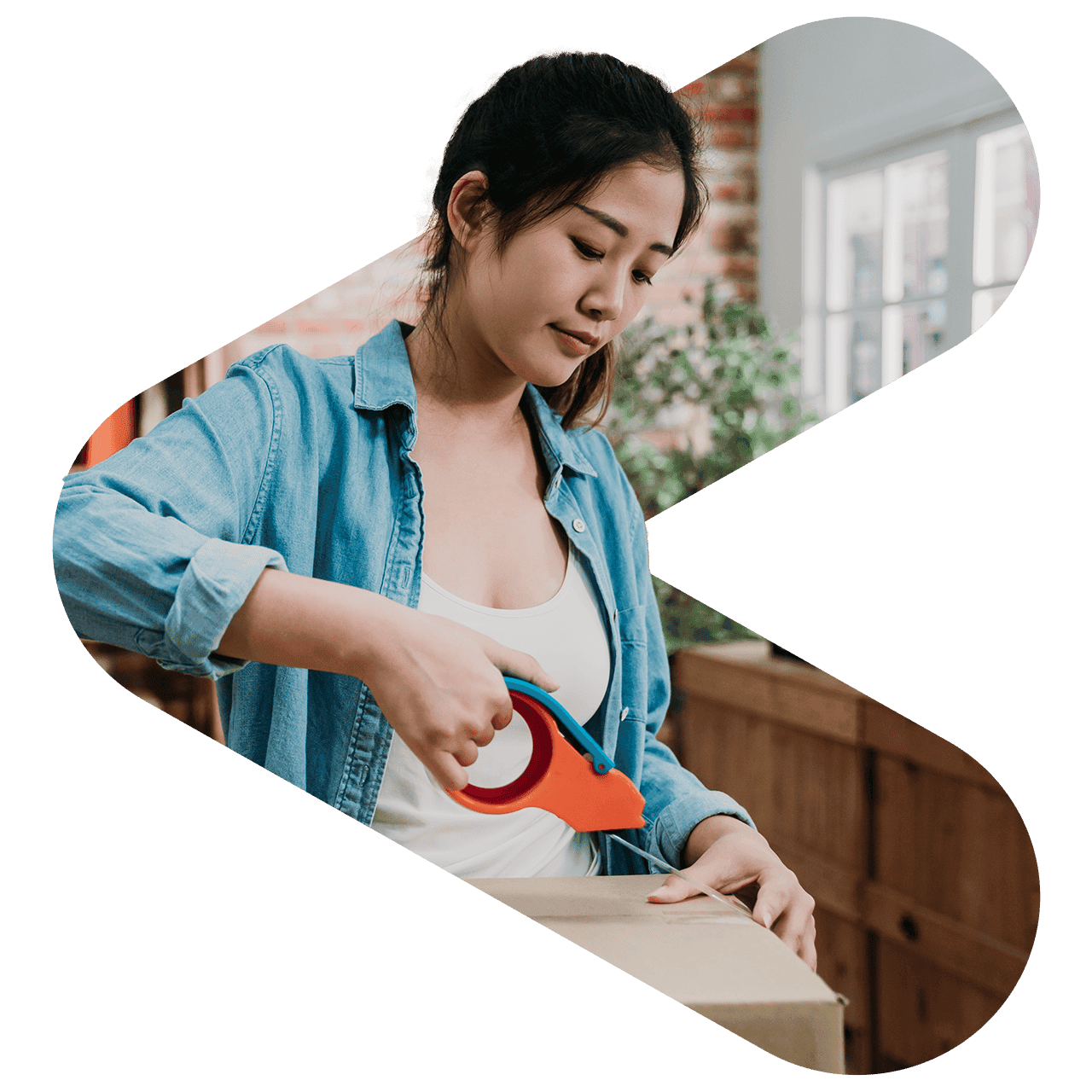 a woman taping a cardboard box closed