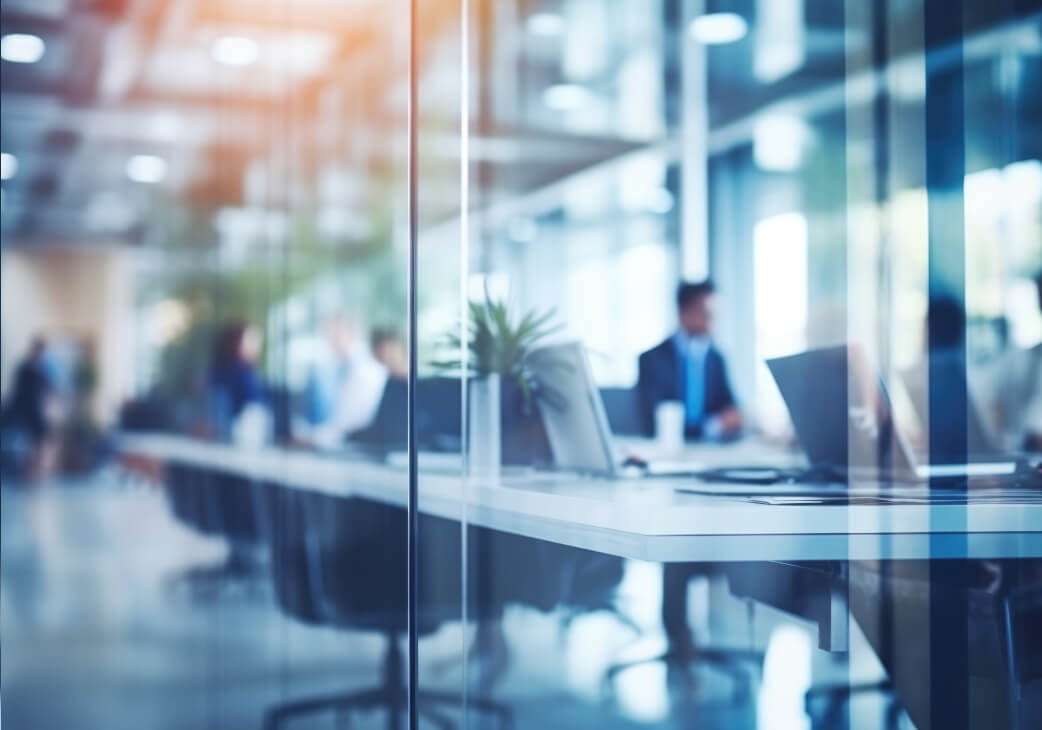 People working in an office behind a glass door