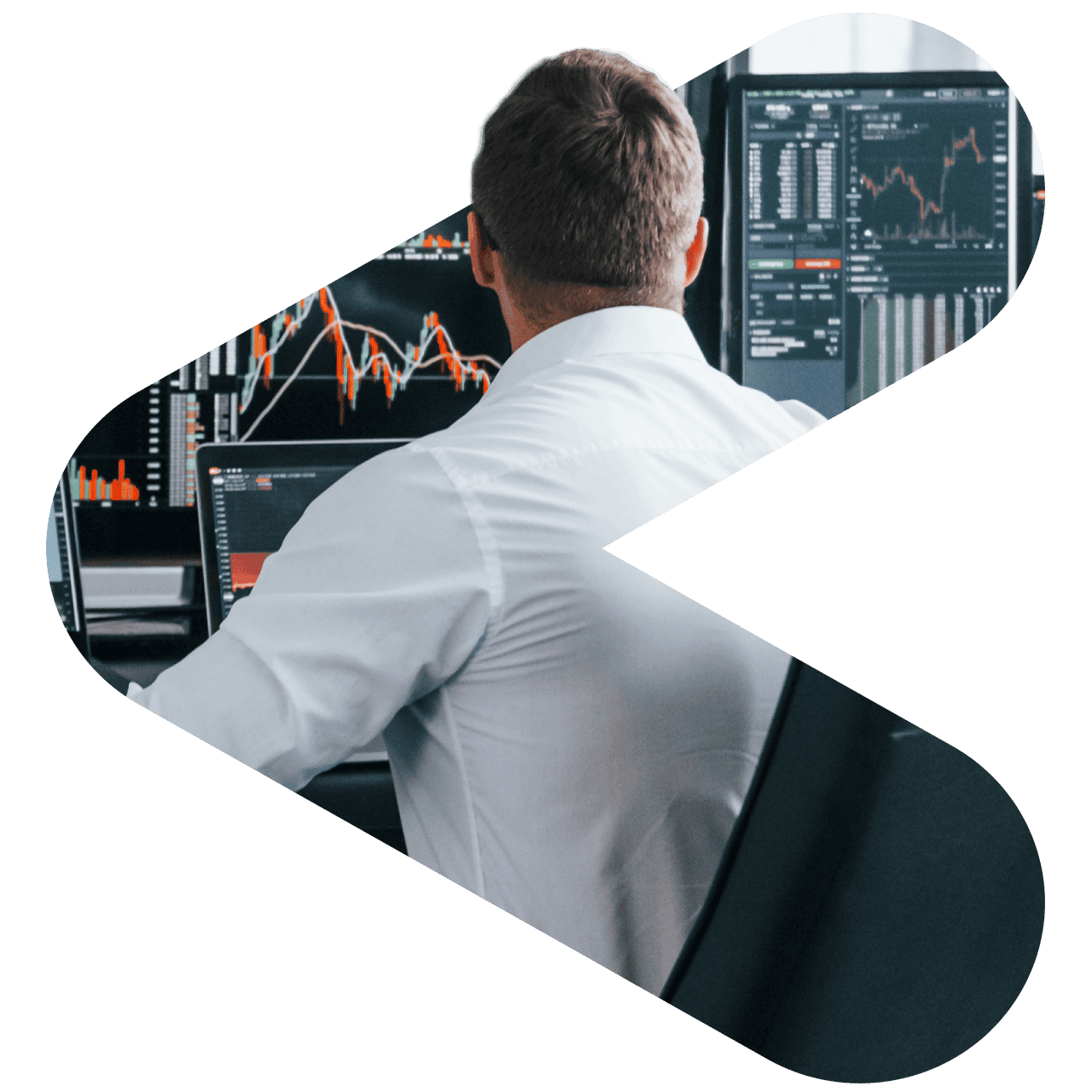 view of the back of a man seated at a desk in front of financial models on a computer screens